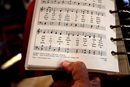 The Rev. Romero del Rosario holds a songbook featuring the lyrics written by Charles Wesley in 1742, "Come, O Thou Traveler Unknown." Photo by Kathleen Barry, UM News.