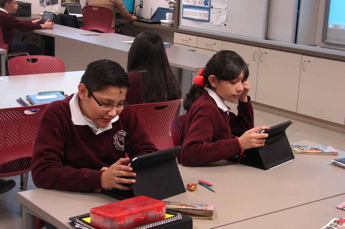 Students work with tablet computers.