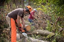 United Methodist volunteers Darren Garrett (front) and Dale Krohn use chainsaws to clear downed trees at a home in Cedar Rapids, Iowa, following an August 2020 derecho. Photo by Mike DuBose, UM News.