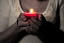 Woman holds candle. Photo by Courtney Carmody, courtesy of Flickr.