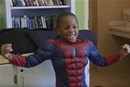 A child tries on a Spiderman outfit at the Nashville Costumes for Kiddos Project shop. Video image by United Methodist Communications.