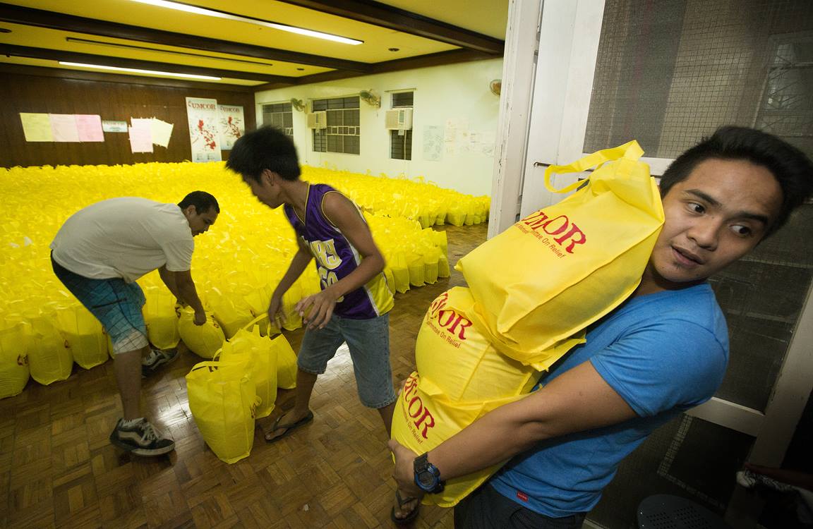 Volunteer Vincent Salazar (right) helps a team with the United Methodist Committee on Relief in Manila as they load bags of relief supplies for survivors of Typhoon Haiyan in the Philippines.