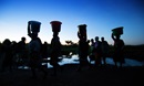 Women carry water as the sun rises at Njenjete village near Madisi, Malawi. Photo by Mike DuBose, UM News.